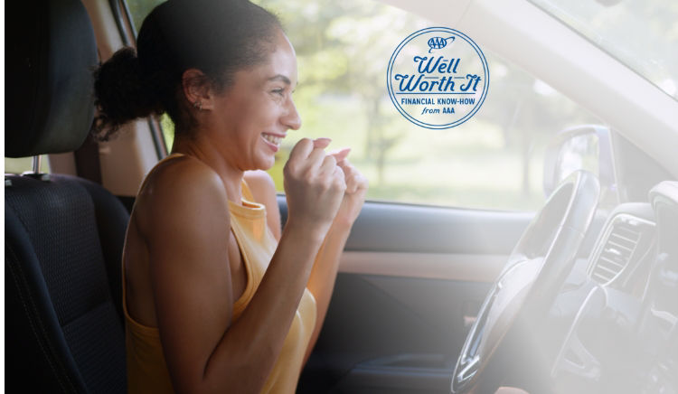 A women sits in her new car she just bought celebrating in excitement. 