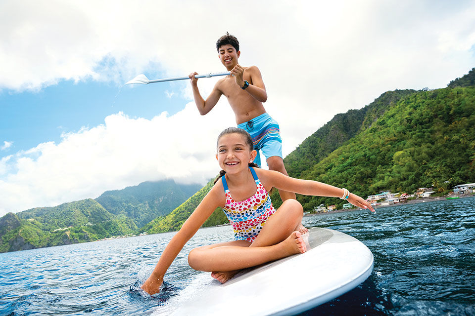 Dominica, Scotts Head Bay, brother sister paddleboarding, paddle board, family fun, tropical island in background, kids, teens