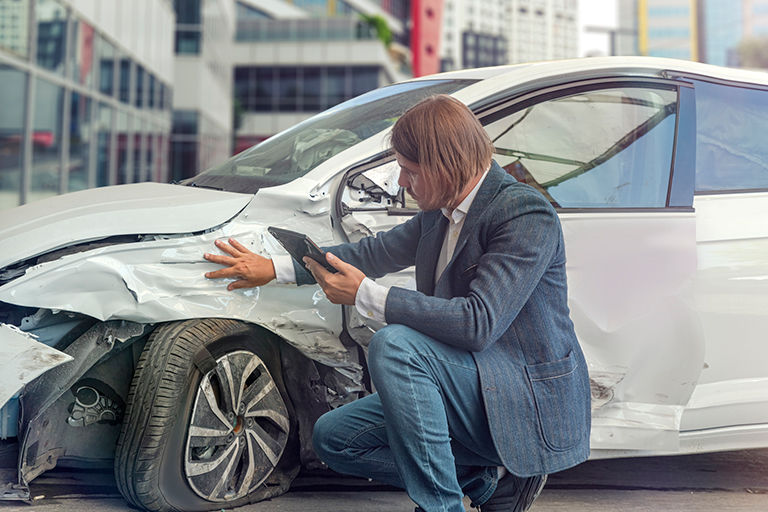 Insurance agent assessing the car damage after the accident.