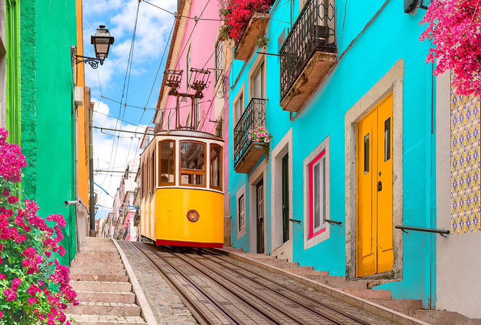 Yellow street car if front of brightly colored buildings