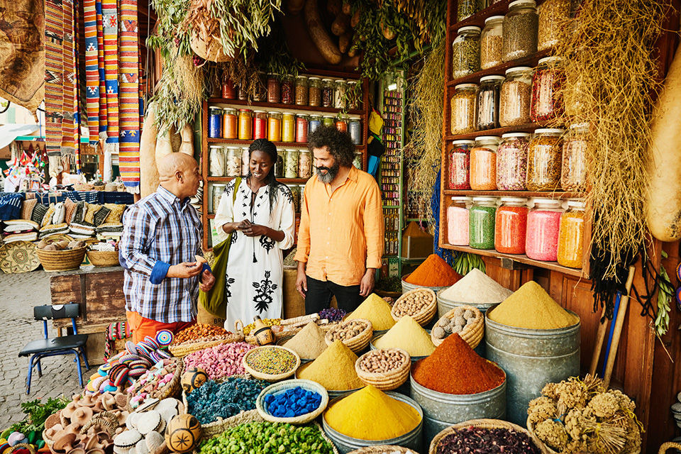 Couple in the market purchasing fresh spices on a memorable vacation through AAA.