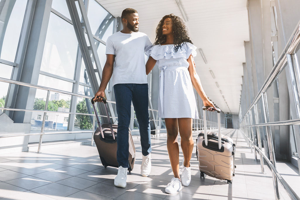 On way to honeymoon. African-american couple travelers with suitcases at airport, freee space