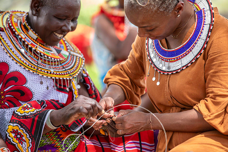 Cultural skills exchange with indigenous community members in colorful traditional dress.