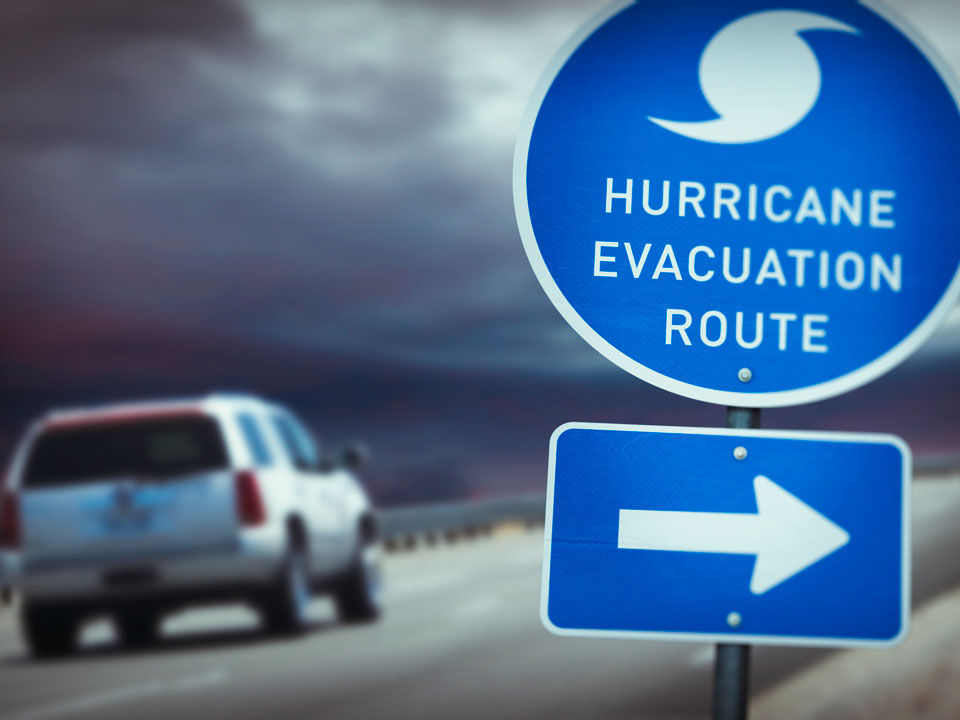 vehicle leaving with hurricane evacuation route sign
