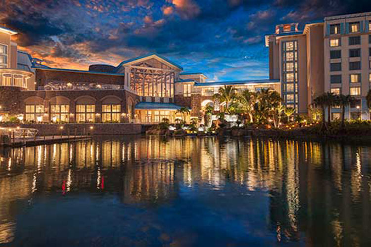 Nightime view of universal's loews sapphire resort as the lights from the building illuminate onto the water.