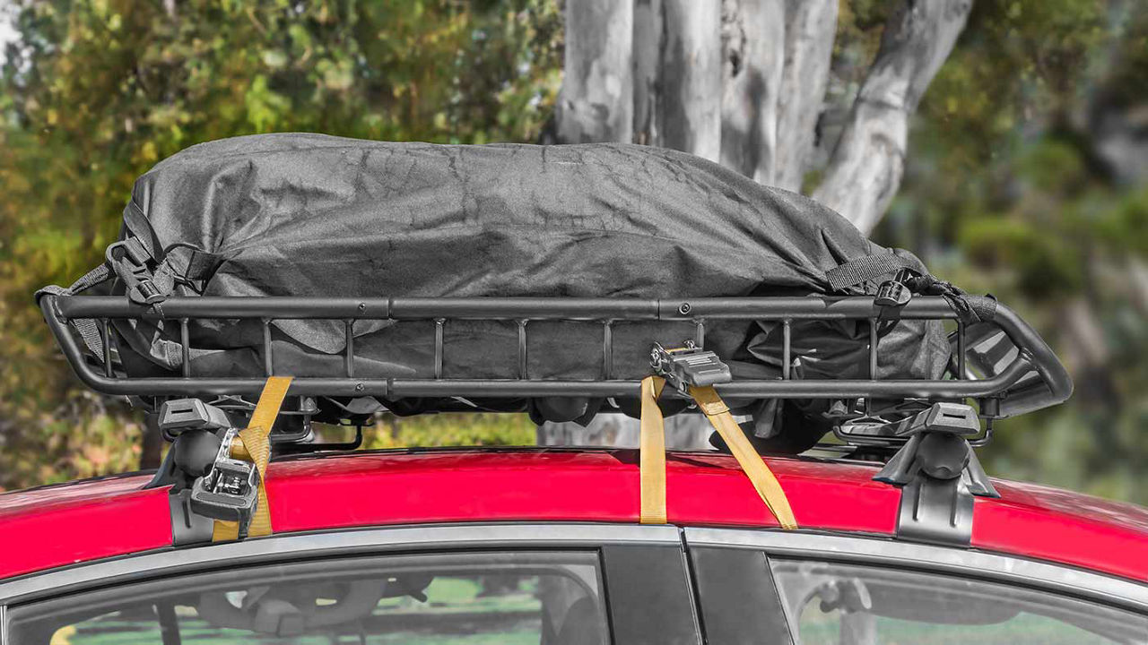 A car roof top carrier filled and covered with a tarp.
