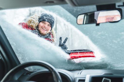 Cleaning snow off of a car in winter
