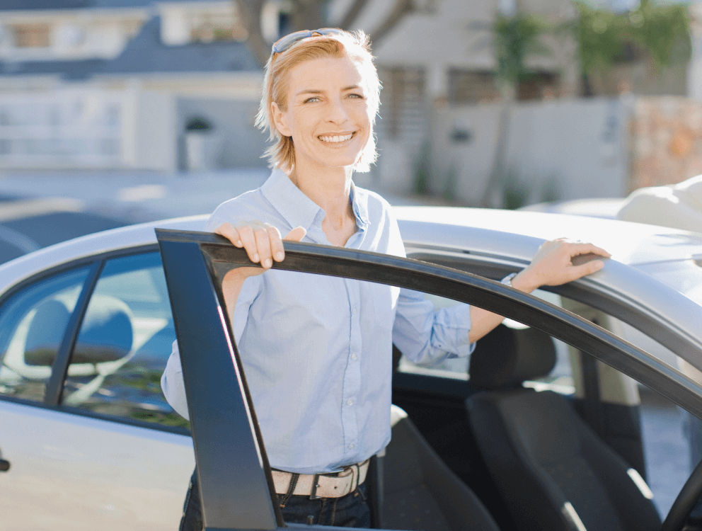 A woman getting into a car