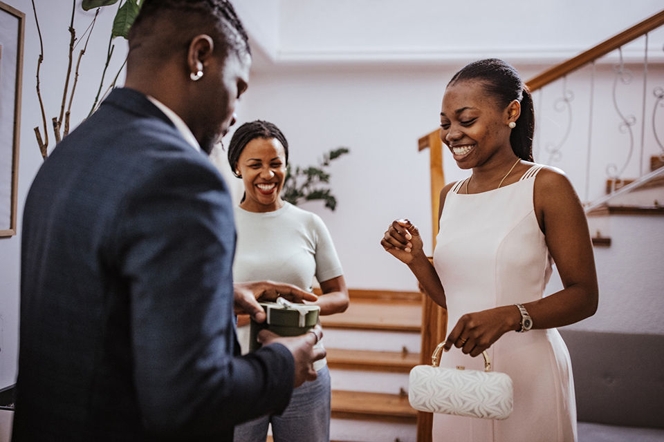 Teenage boy in formalwear presenting corsage to his date.