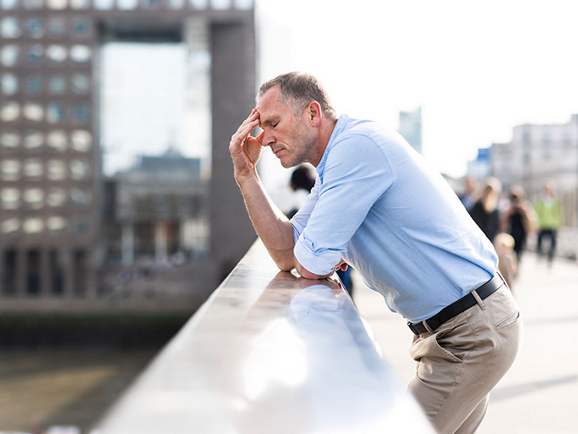 Man not feeling good, leaning on bridge at London, UK